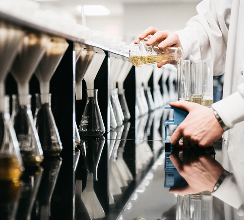 brewing scientist decanting flasks of wort